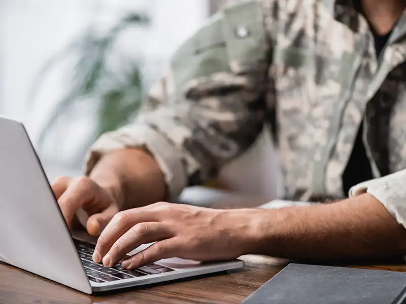 Military personnel using a laptop